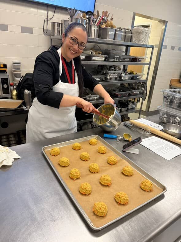 Chef  Kristianne Descher, standing in the kitchen, preparing pastry