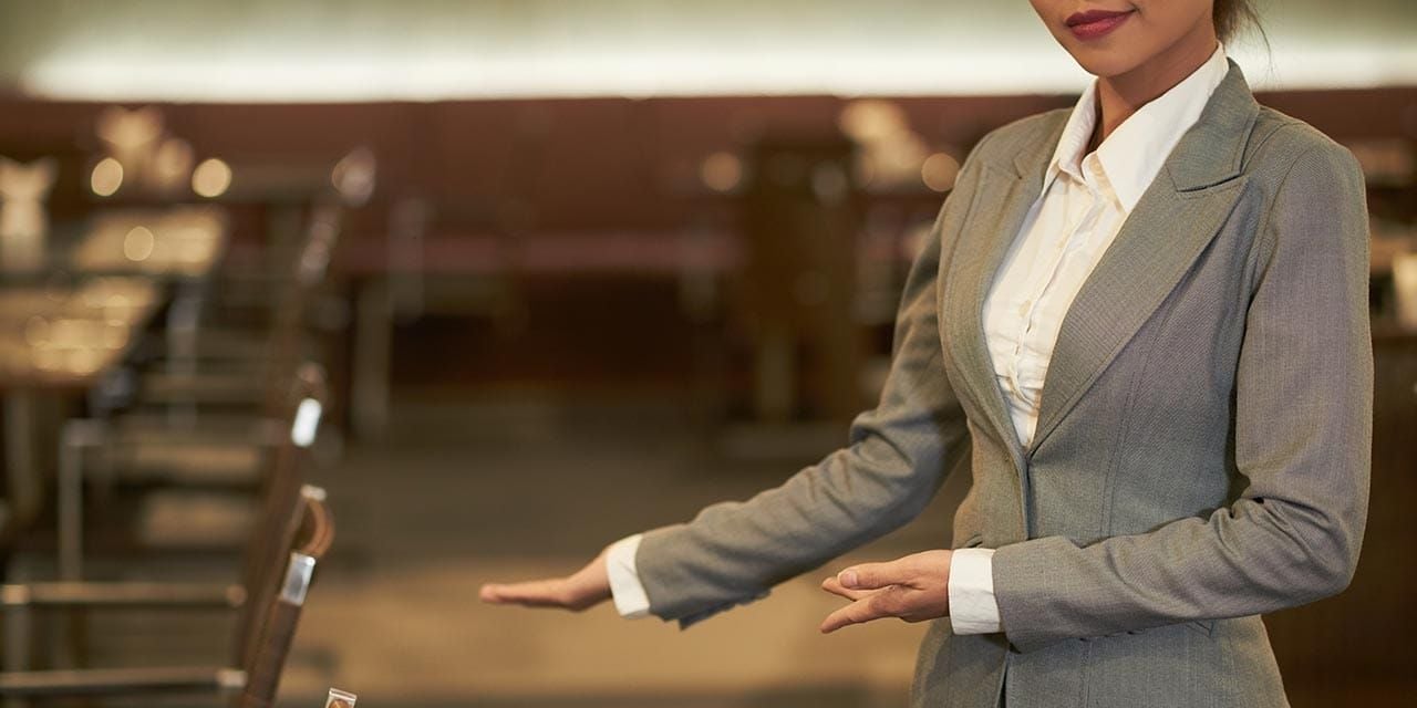 hostess showing restaurant guests where to sit