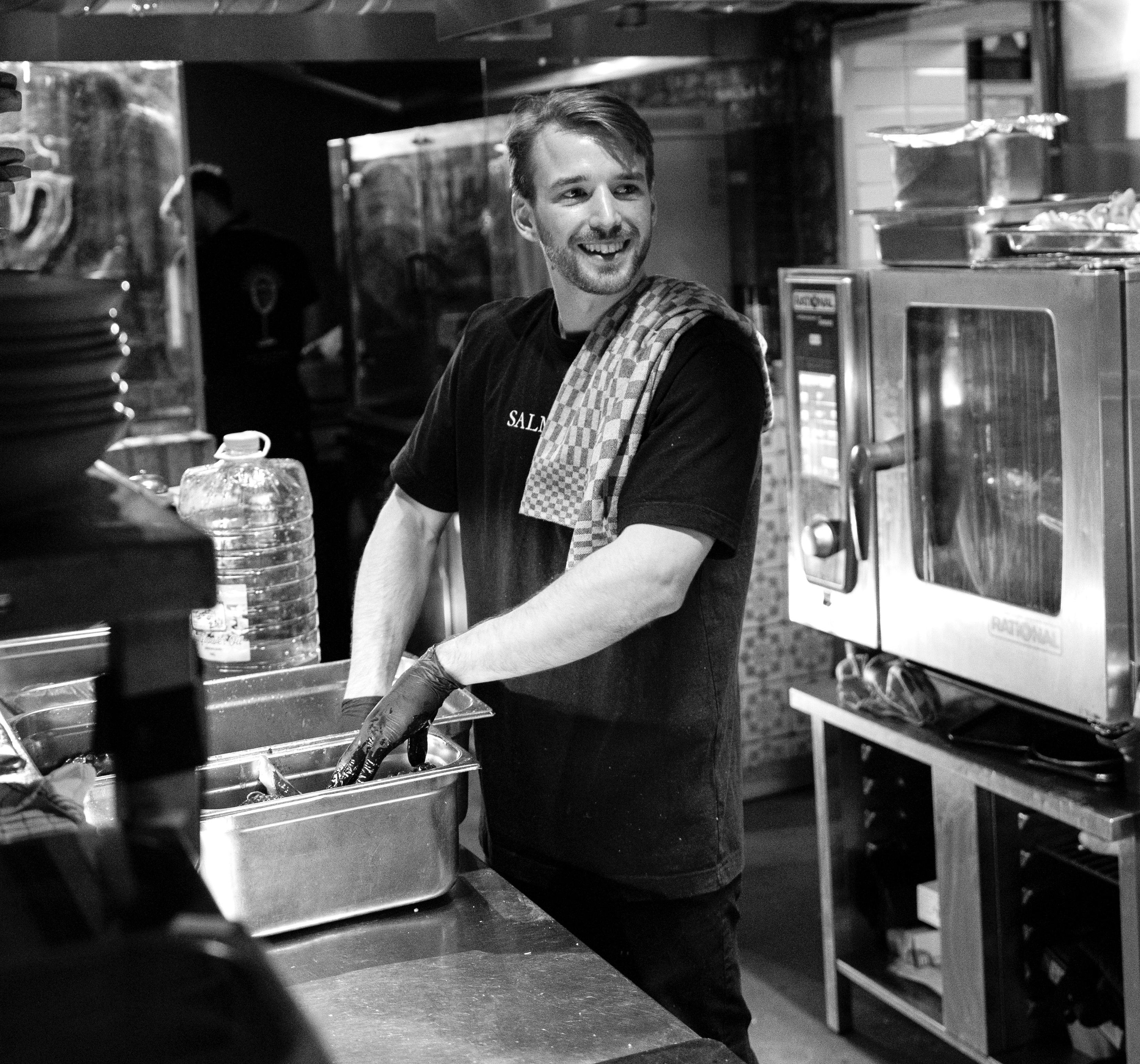 Chef Juan Fortunato working in the kitchen and smiling