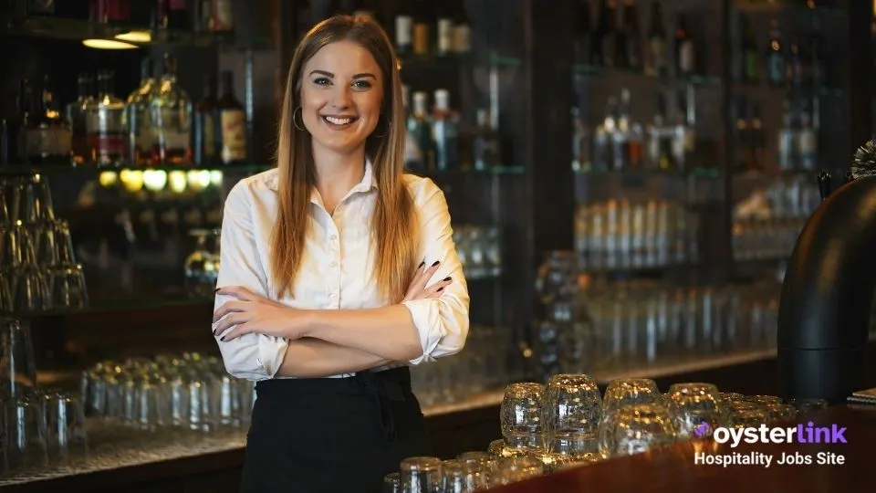 smiling barback standing behind the bar