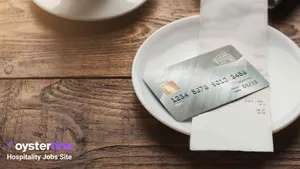 Credit card and receipt on top of a plate on a wooden table