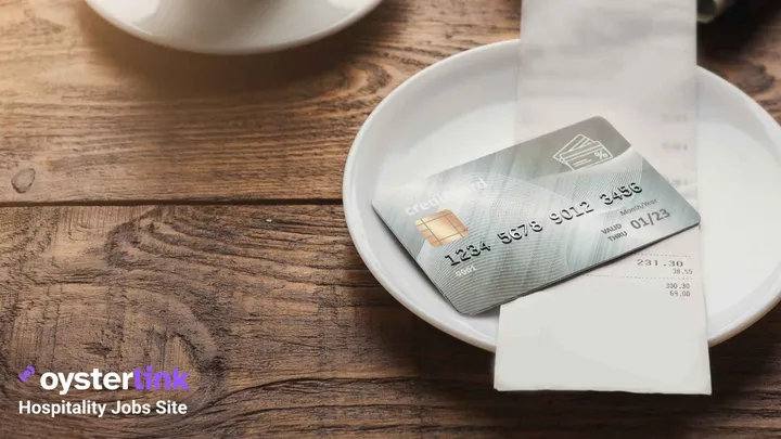 Credit card and receipt on top of a plate on a wooden table