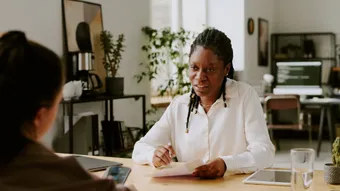 Female Black or African American Manager interviewing an applicant