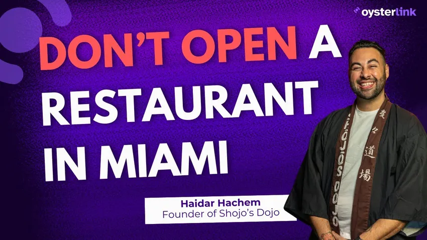 Haidar Hachem holding a bottle of sake and smiling to the camera