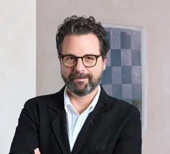 David Hellbronn standing, wearing a black suit