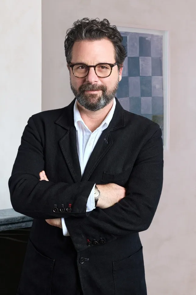 David Hellbronn standing, wearing a black suit