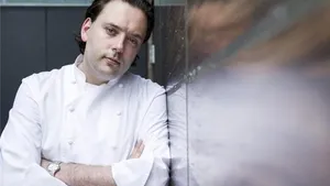 Chef Paul Liebrandt in a black & white photo holding a knife in the kitchen