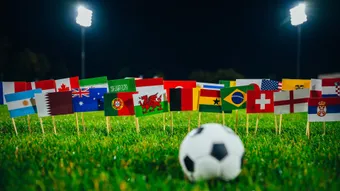Football on the ground facing several flags
