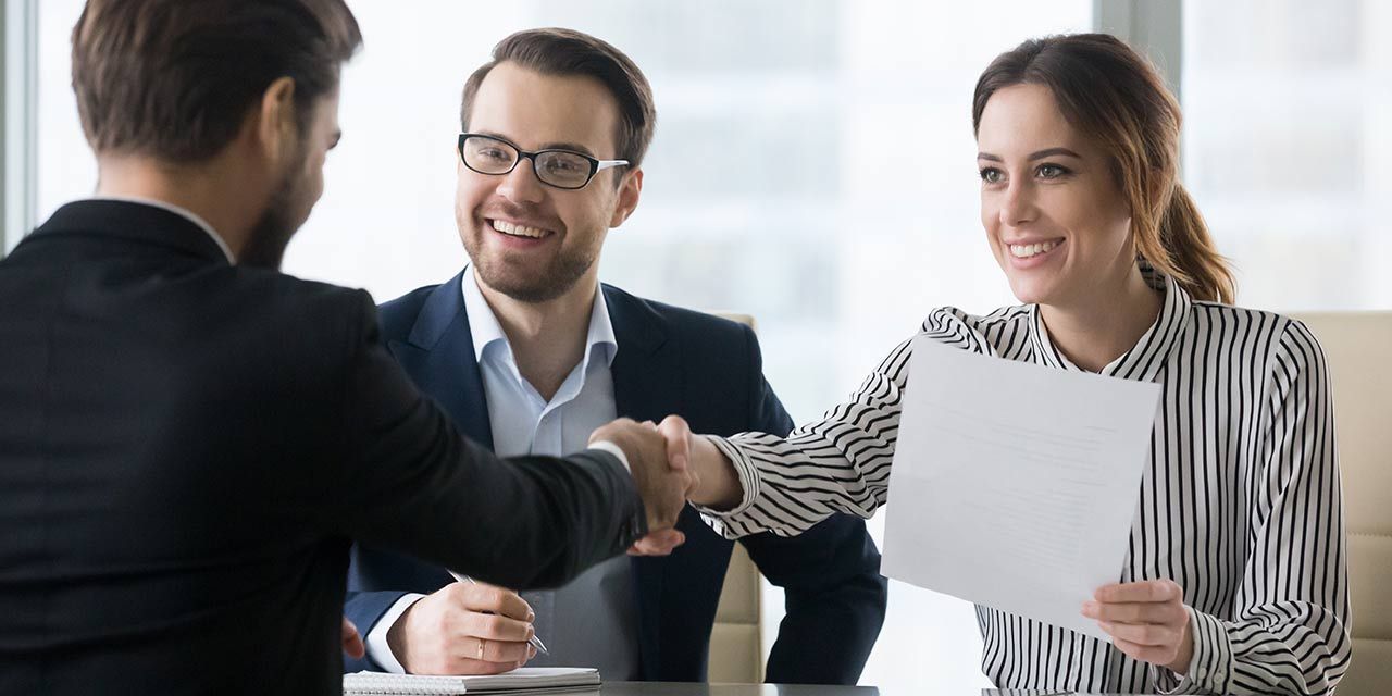 A female employee shaking hands with her boss