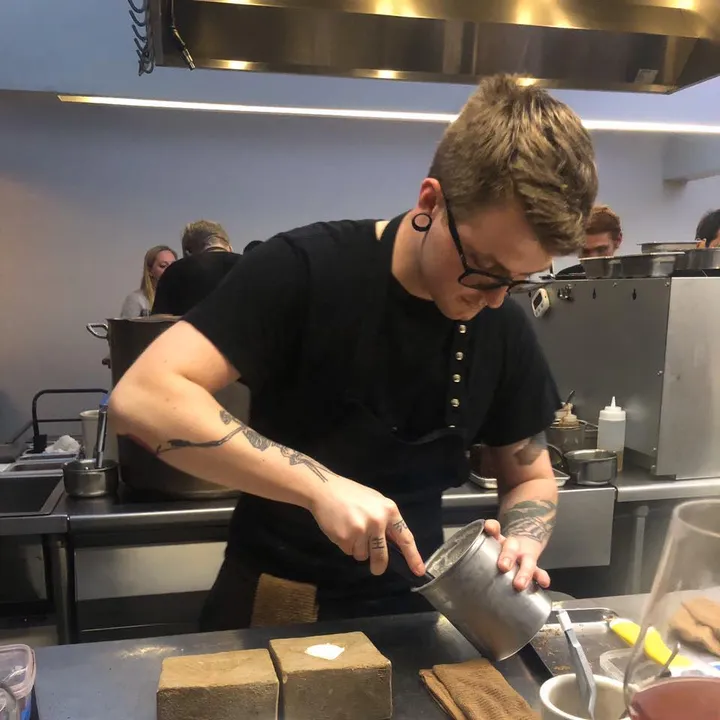 Black and White photo of Chef Daniel Lugovtsov sitting in the kitchen