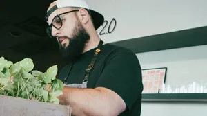 Chef Pedro Mederos wearing an apron, standing in a kitchen, and working