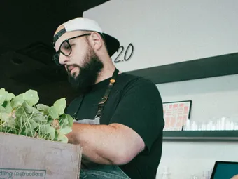 Chef Pedro Mederos wearing an apron, standing in a kitchen, and working