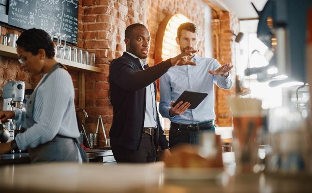 A restaurant manager discusses the table arrangements in a restaurant