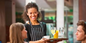 A female Waitress smiling and serving customers