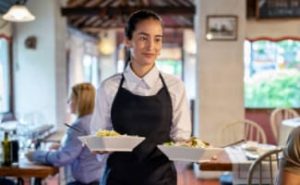 Waitress serving two dishes and walking to the customer