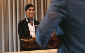 A female concierge flashing a smile on a male guest