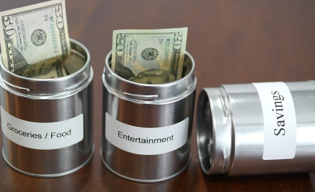 Labeled metal jars used for paycheck budgeting