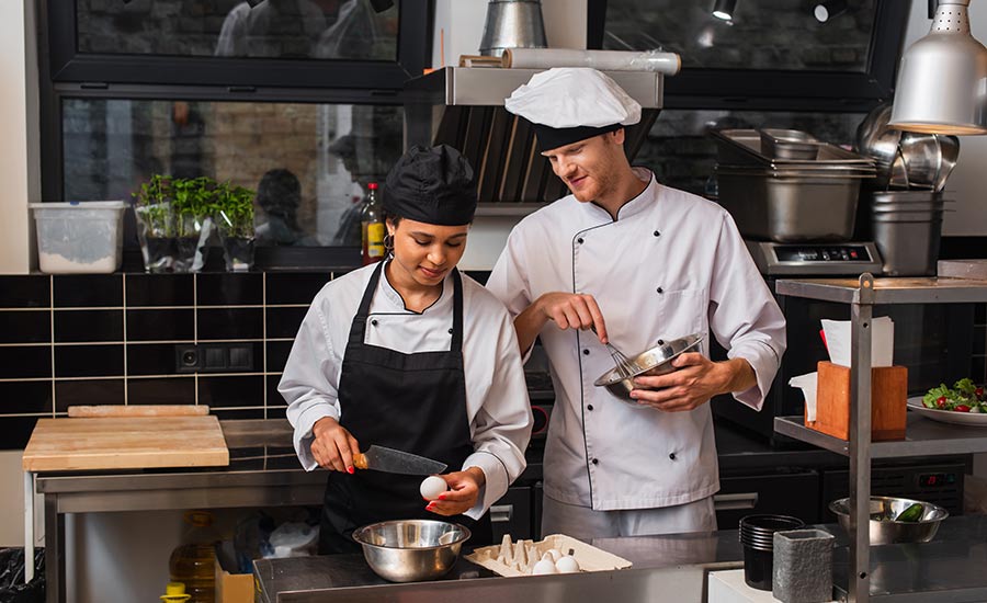 head chef and sous chef working in a restaurant kitchen
