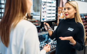 A beauty advisor showing products to a customer