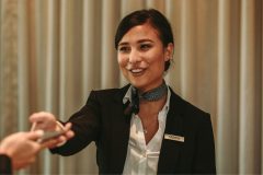 A female guest relations officer holding out her hand to a guest