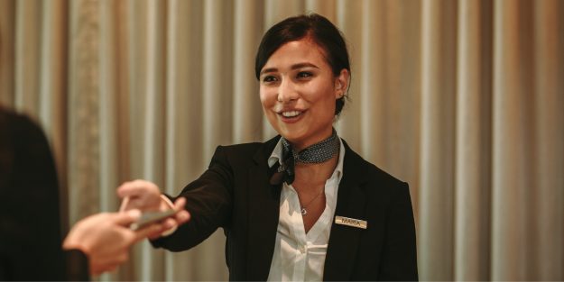 A female guest relations officer holding out her hand to a guest
