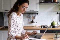 house manager in the kitchen, typing on the laptop