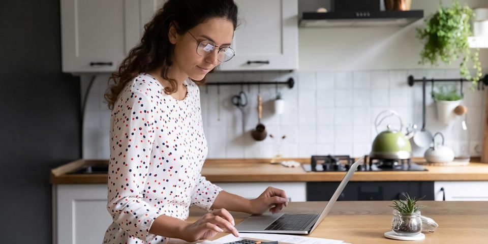 house manager in the kitchen, typing on the laptop