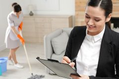 A housekeeping supervisor in a suit taking notes