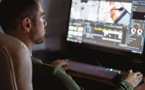 A male video editor editing a video on his desktop