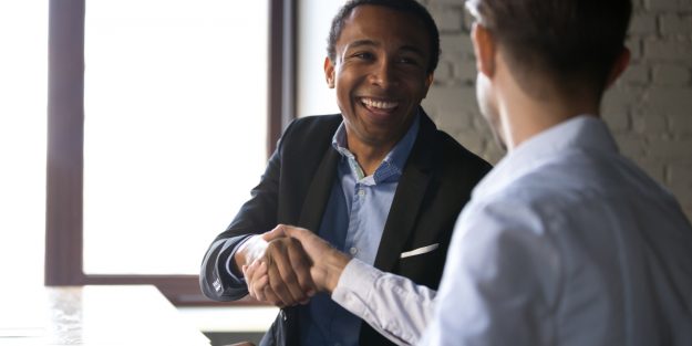 A male client relations manager shaking hands with a client