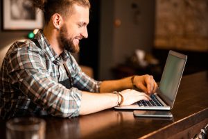 bartender typing on laptop