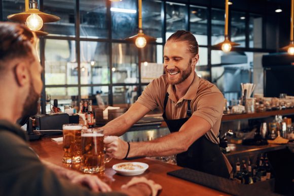 Bartender Serving Beer to Customers