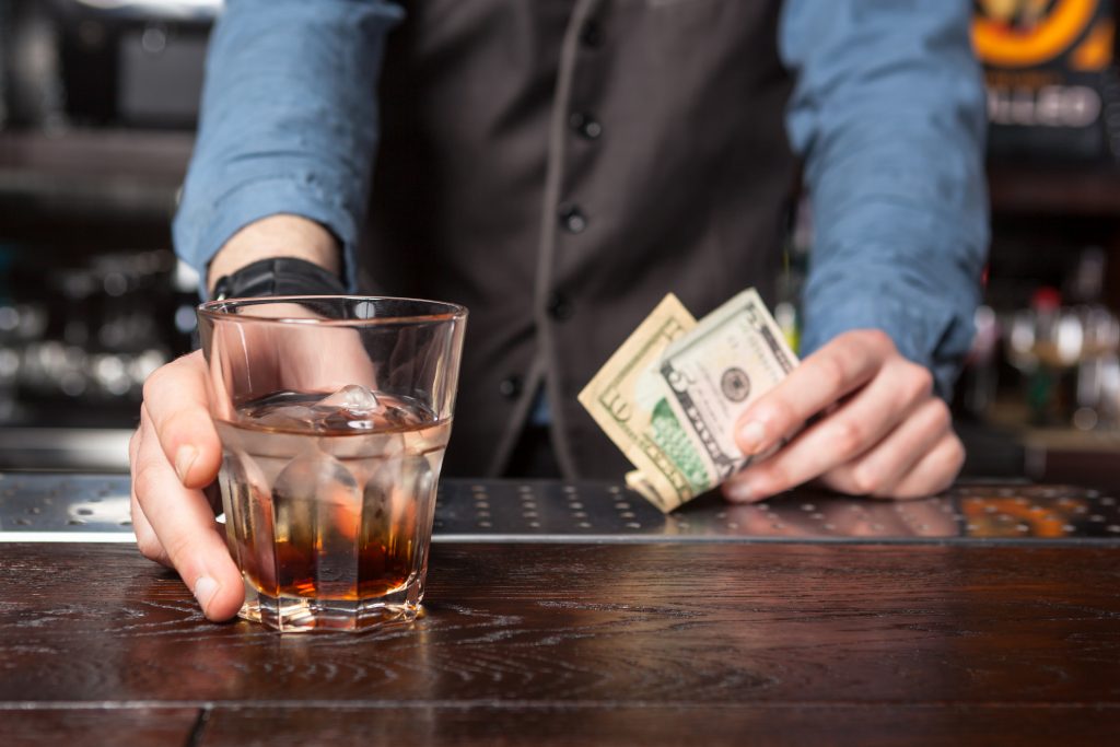 bartender serving drink receiving tip