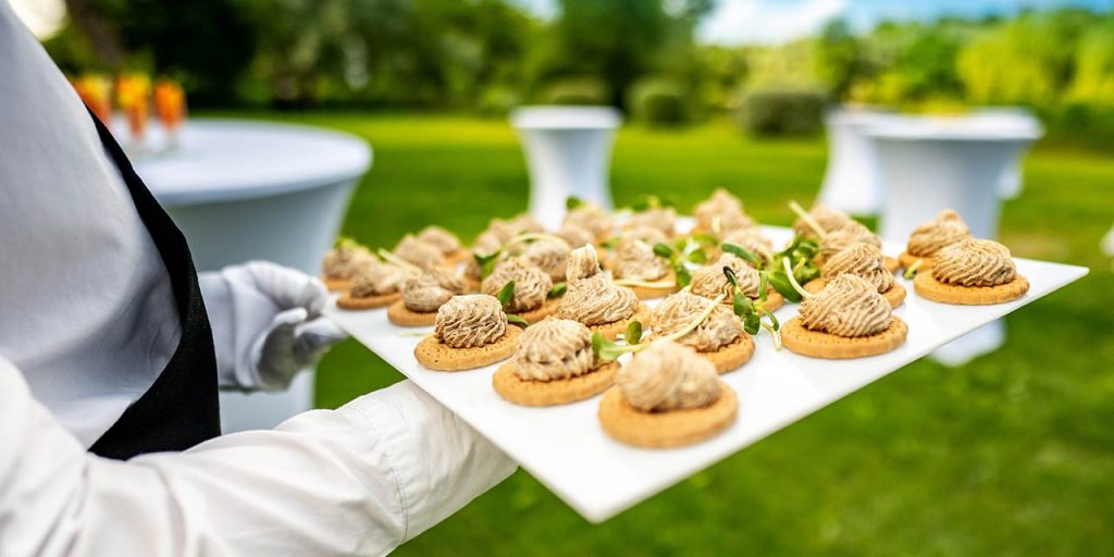 A server holding a tray with canapes