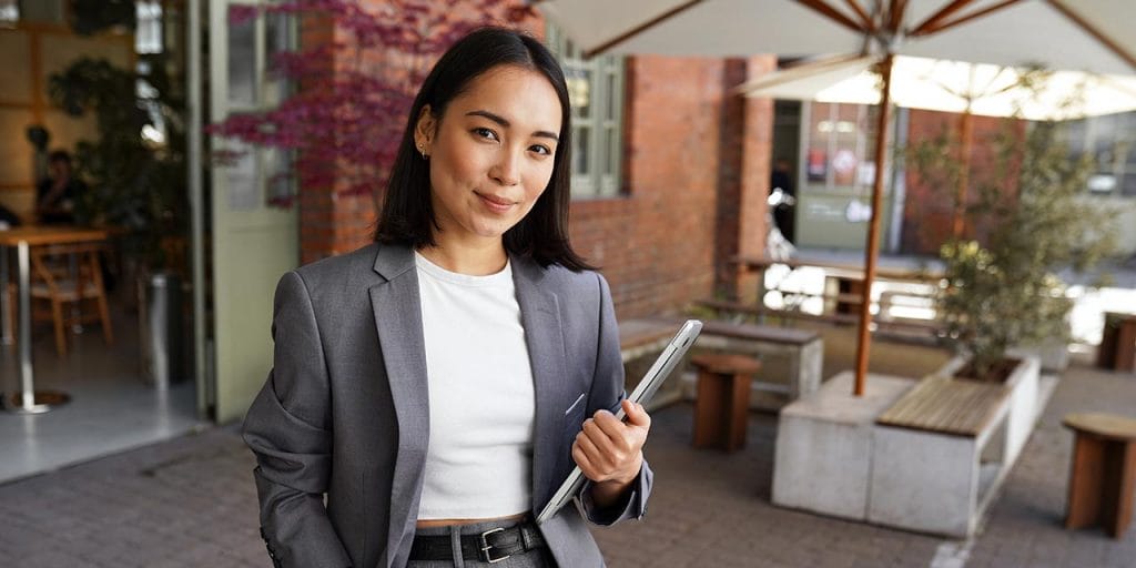 a hostess in a gray business suit standing outside the restaurant