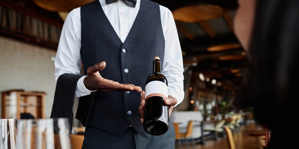 server pointing at the wine label