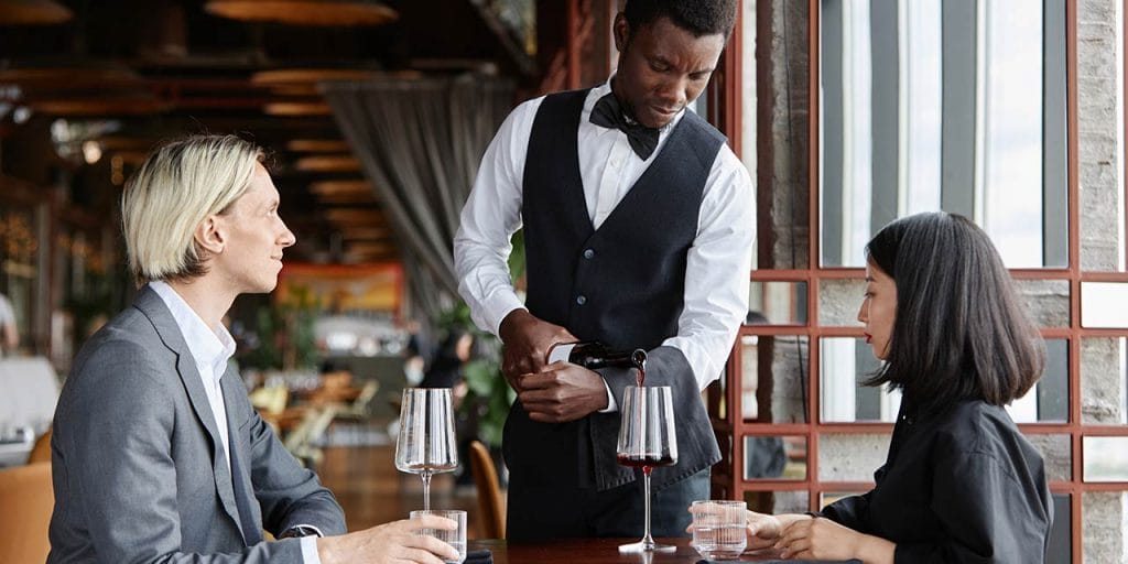 server pouring wine for customers, wine knowledge for servers