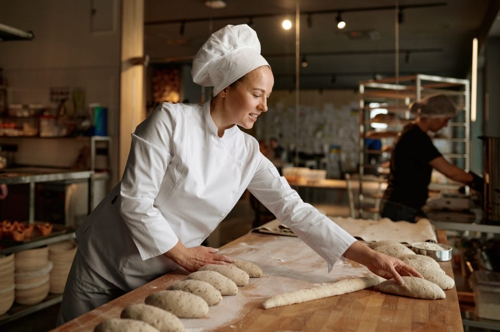 Female Baker kneading and preparing dough