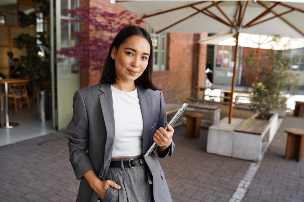 Female Restaurant Manager holding a clipboard with one hand in her pocket