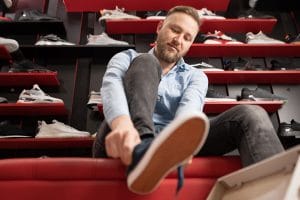 a man trying on shoes at the store