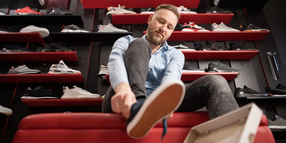 a man trying on shoes at the store