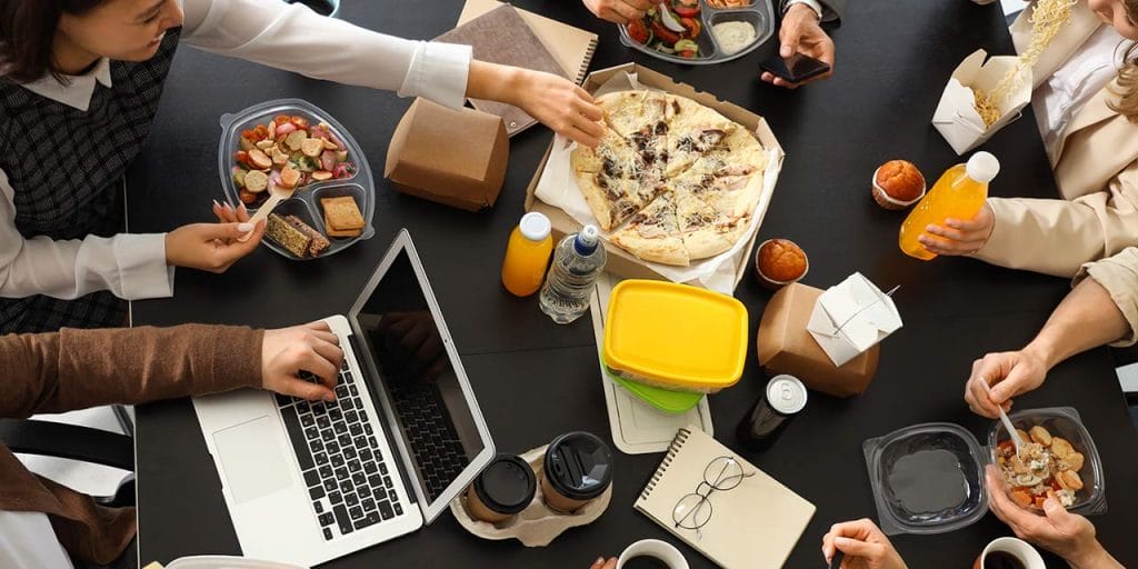 work colleagues sharing pizza for lunch