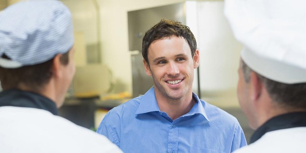 restaurant manager providing feedback to chef and sous chef