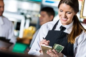 a smiling server taking payments from guests