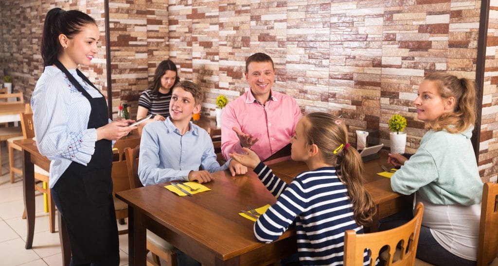 a little girl talking to a waitress