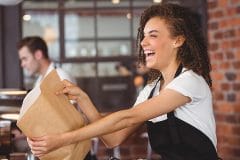 smiling service worker handing bag