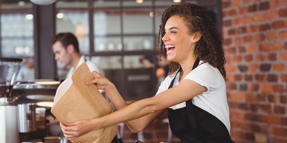 smiling service worker handing bag