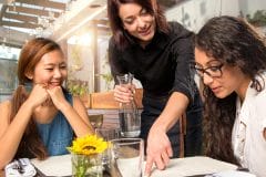 waitress explaining menu to patrons