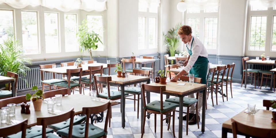 waiter clearing up a table