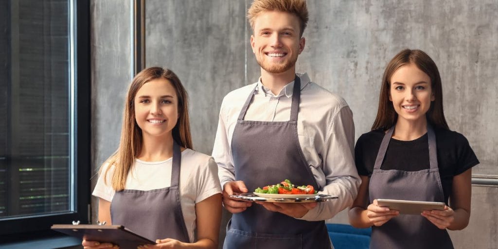 3 servers smiling to the camera